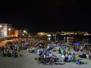 La sombrillada nocturna de les festes de s’Illot uneix generacions de silloters i silloteres en el sopar a la platja