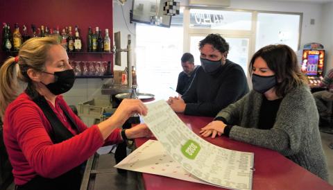 La directora de l’Escola Municipal de Mallorquí, Margalida Rosselló i el delegat de Política Lingüística, Sebastià Llodrà, han obsequiat la propietària del bar Gallo amb el primer dels calendaris de 2022.